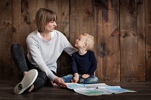 Mutter und Tochter sitzen nebeneinander und schauen sich naserümpfend an.